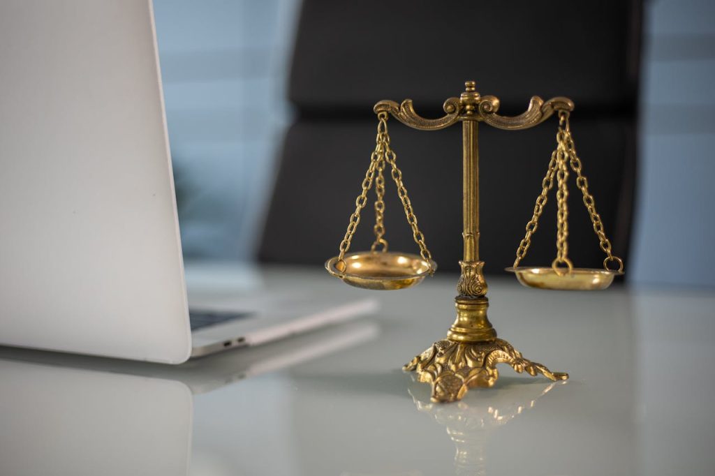 a-golden-balance-scale-beside-a-laptop-6077797 Golden justice scales on a desk beside a laptop, symbolizing law and balance.